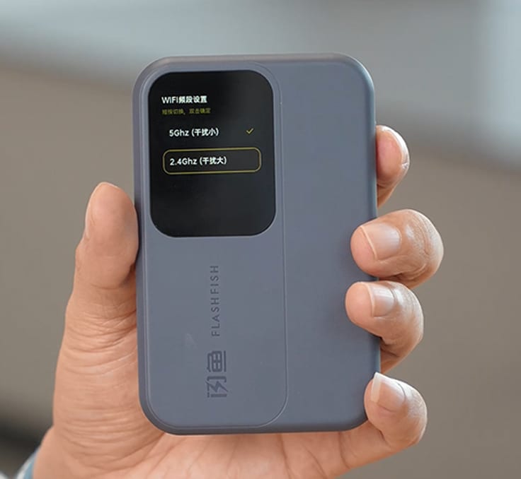 手持闪鱼随身 WiFi，屏幕显示 5GHz 与 2.4GHz 频段切换